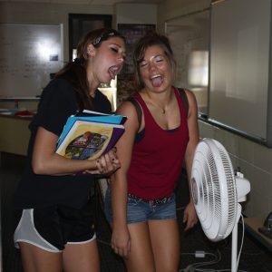 Sydney Pitstick and Samantha Livingston cool off in front of a fan during break.
