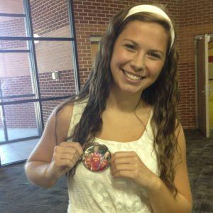Emily represents her team by wearing a cross country button.