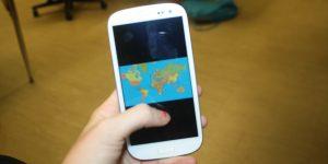 A phone showing a map of the world that could be used for research in many classes.