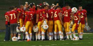 Football team during a huddle mid game.