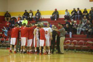 The varsity boys basketball team huddles before a game begins. 