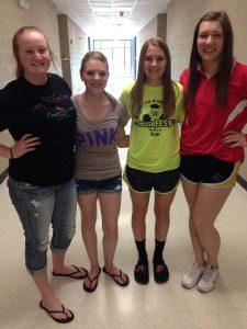 Four students wearing appropriate summer clothing.