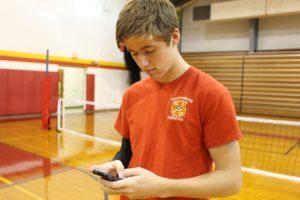 Noah Walters, senior, checking his iPhone 5s during gym class