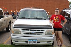 Isabelle Webber, junior, standing with her newly bought car