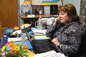 Anne Grant, one of the counselors in the Student Services office, talks on the phone at her desk