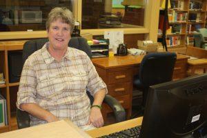 Mary Bandhurst, the new media associate in the library, sits behind her desk 