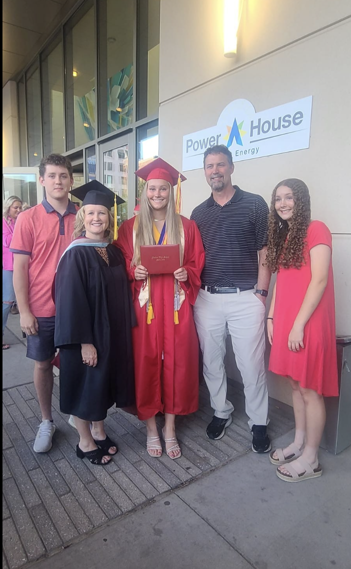 The+Johnson+family+smiles+for+a+photo+at+Peyton+Johnsons+graduation.+Both+Peyton+and+Mrs.+Johnson+wear+a+cap+and+gown+as+faculty+member+and+graduate.