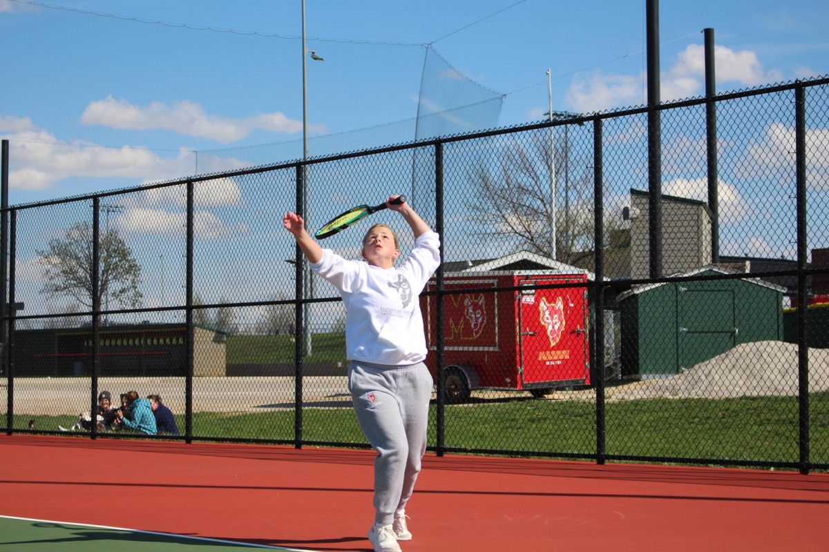 Kasia Hahn, senior, warms up her serve before a tennis match. 