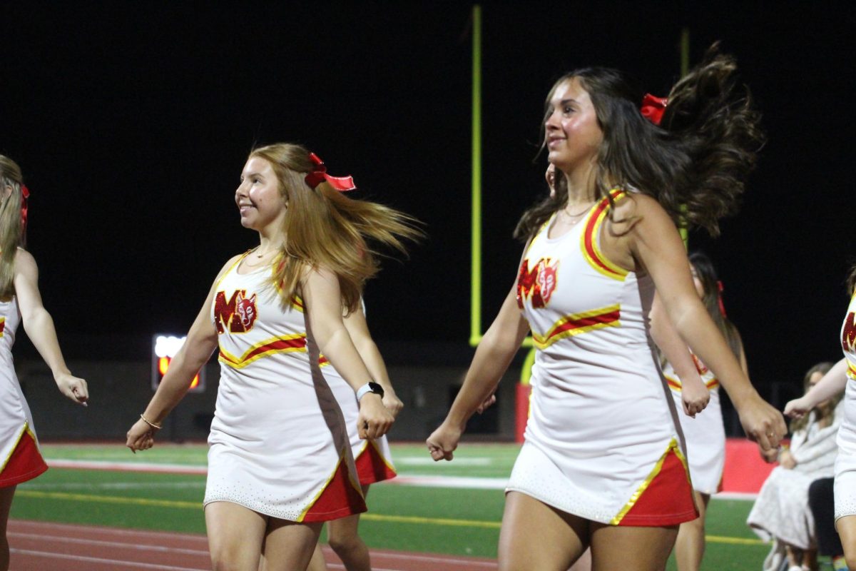 Elle Lindaman, senior, and Lilah Hernandez, junior, perform their routine for the crowd and the Homecoming pep rally.