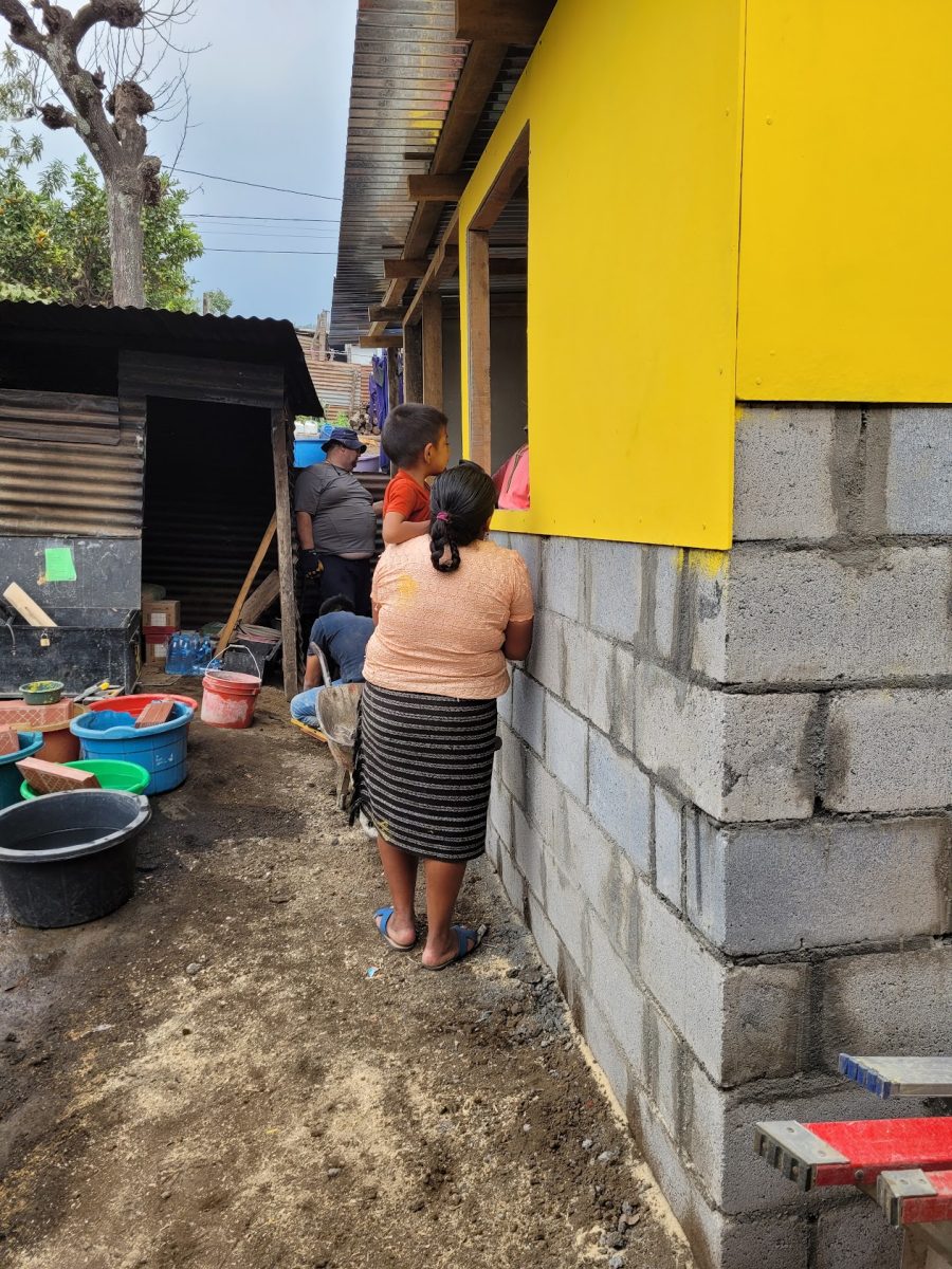 Two members of the Guerra Dondiego family peer through the window of their new home.
