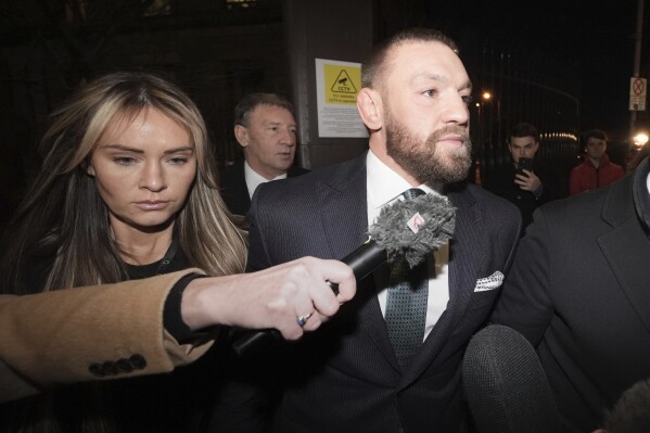 McGregor walks out of the courthouse with his wife Dee.