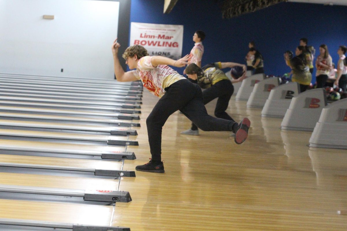 Cole Angell, '26, throws his bowling ball down the lane in hopes of getting a strike.