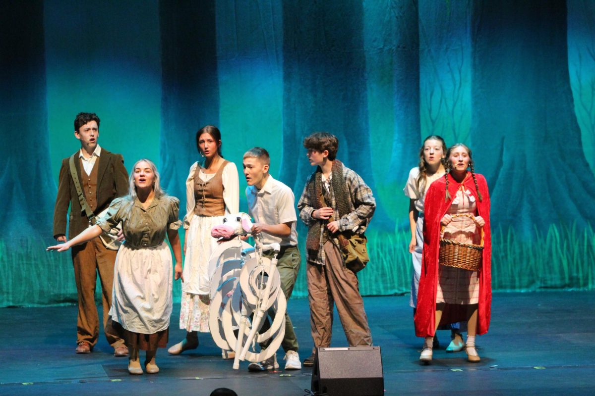 An ensemble of cast members from the spring musical, "Into the Woods," performs for the eighth graders during a matinee performance.