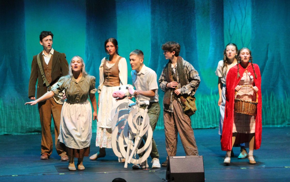 An ensemble of cast members from the spring musical, "Into the Woods," performs for the eighth graders during a matinee performance.