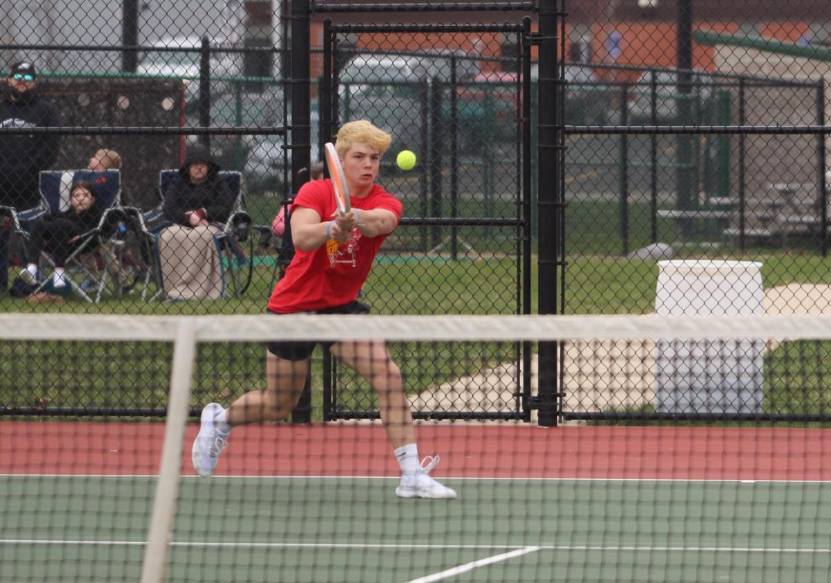 Devin Hendricks, '26, hits the ball with ease during a doubles match.