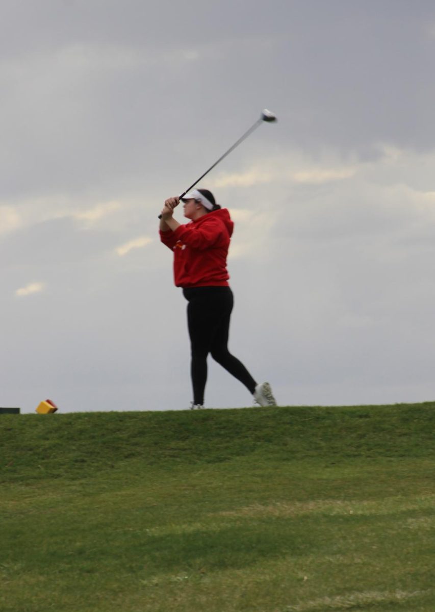 Isabella Aguilar-Lingo, '27, follows her shot during a home golf meet.