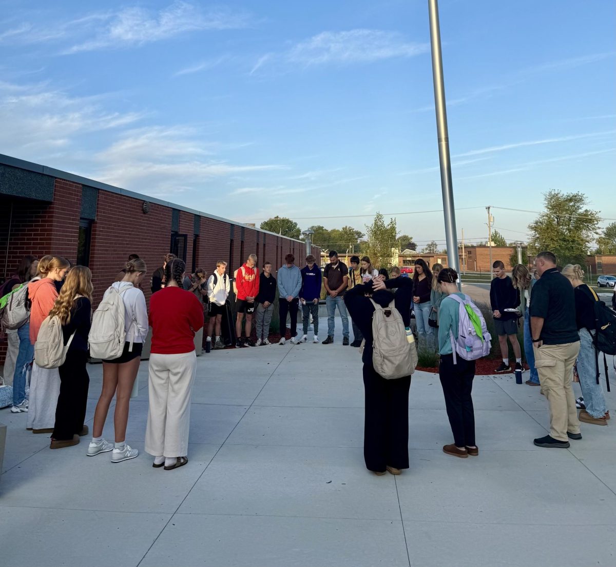 A group of students and teachers involved in Rooted dedicate a few minutes to prayer before the school day. 