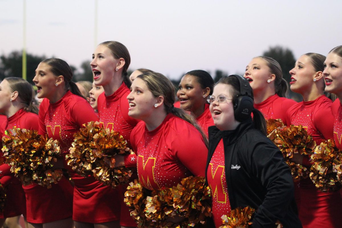 The poms team joins together on the sidelines to get the student section on their feet.