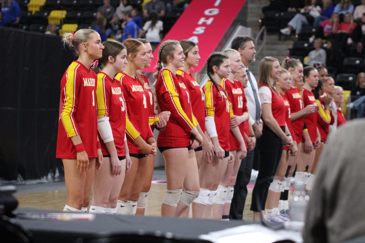The Varsity volleyball team waits while opposing team players are introduced. The team worked hard for this moment at State.