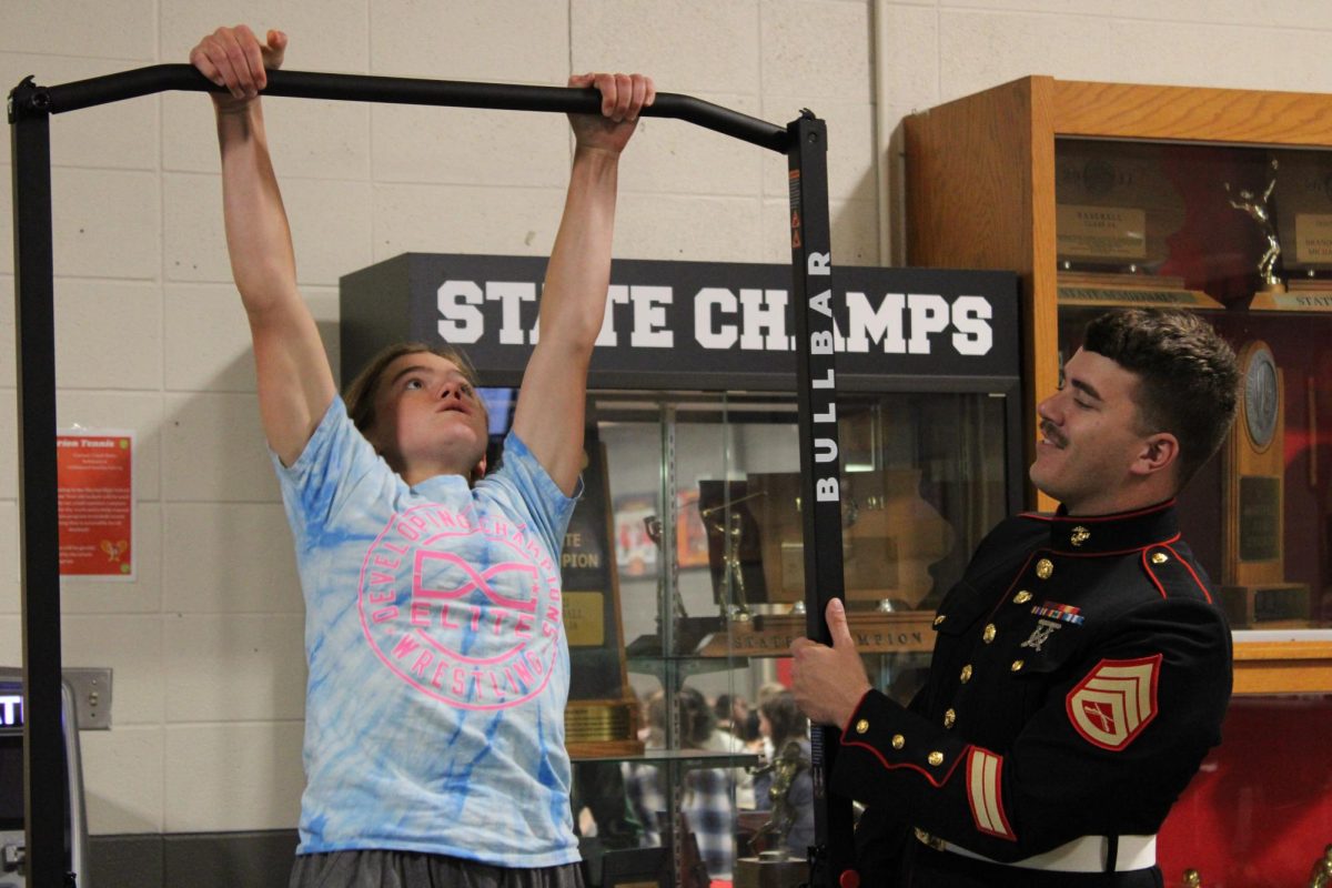 A Marine soldier is impressed while watching Cadence Pastor, junior, complete pull-ups during a lunch-cycle visit. (Courtesy of Olivia Fisher)