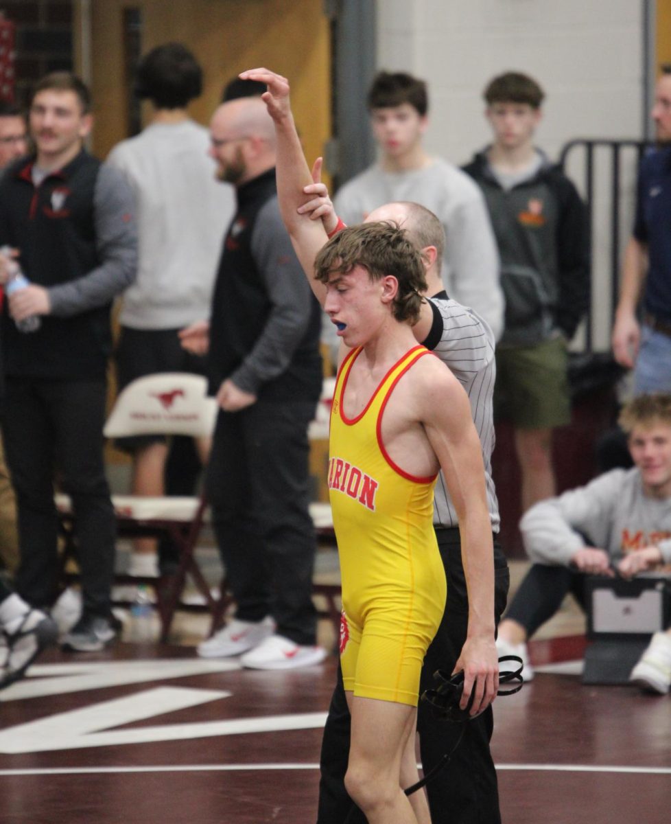Ari Groothuis celebrates his wrestling match and thanks his coaches. This mutual respect between an athlete and their coach is crucial to the sport. 