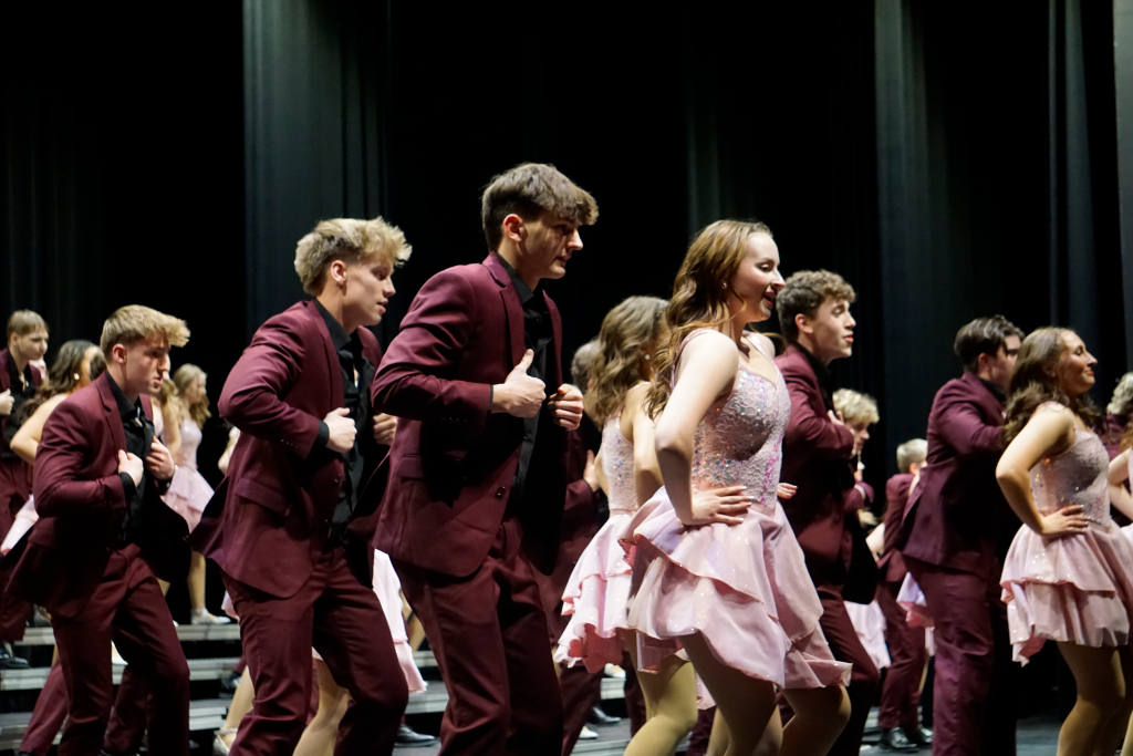 Jameson Turner dances beside other show choir singers at their premier concert. 