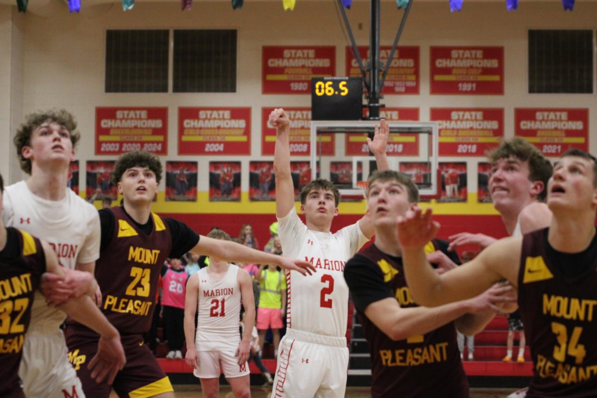 Calvin Andresen, '26, shoots an important free throw in the game against Mount Pleasant as the rest of the surrounding players crash the boards.