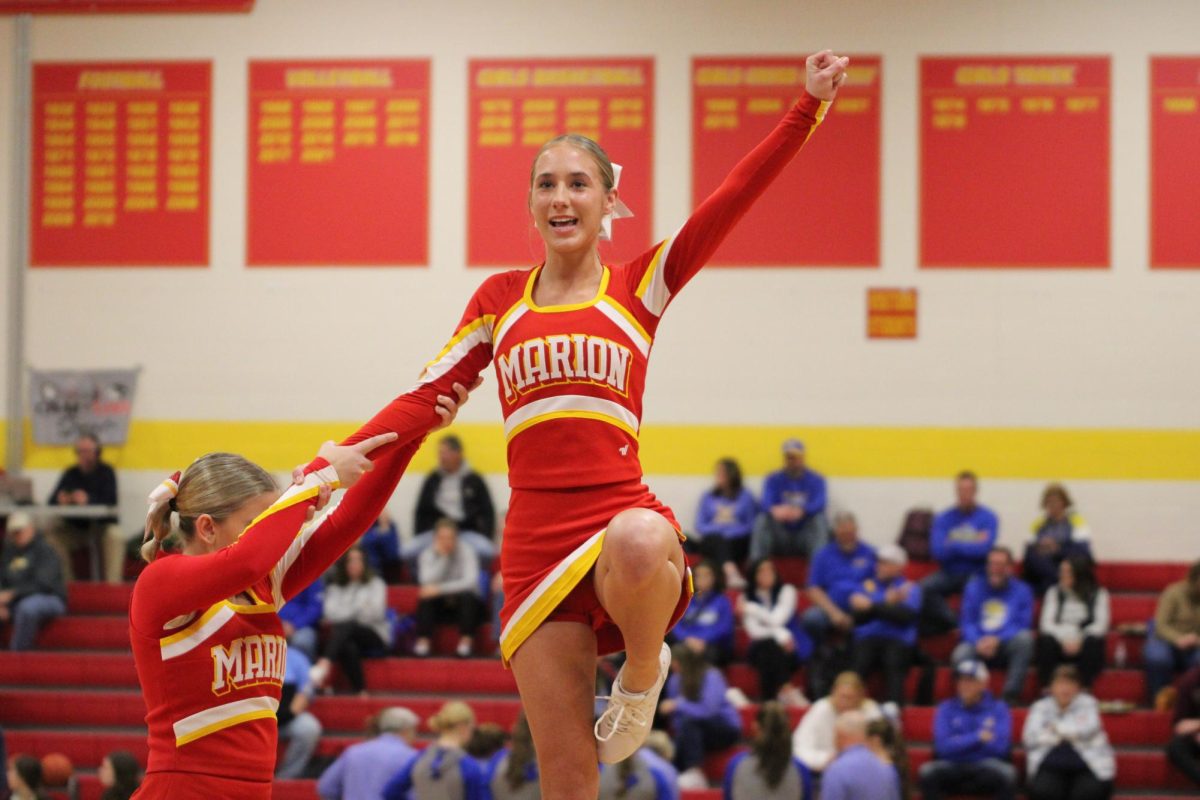 Elise Moore, '26, stunts with the assistance of Hailey Erkel, '27, during a home game.