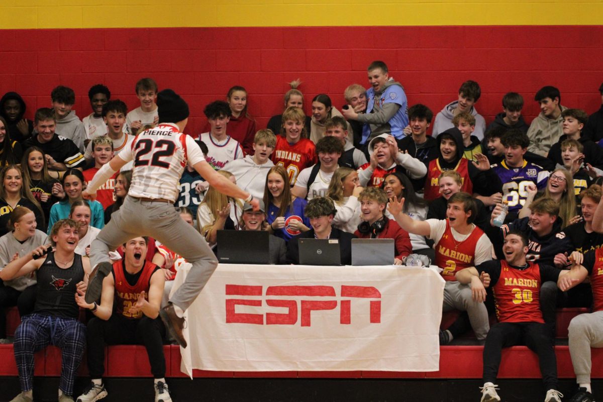 Tyler Pierce, '28, hypes of the student section, during a boys basketball game. 