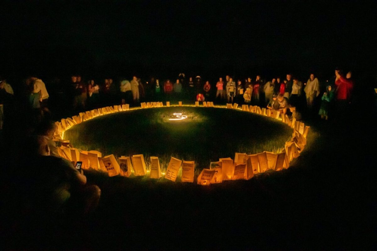 Alive and Running Iowa 5k participants gather around the luminary bag lighting, honoring those who have died by mental illness. (Courtesy of Alive and Running)