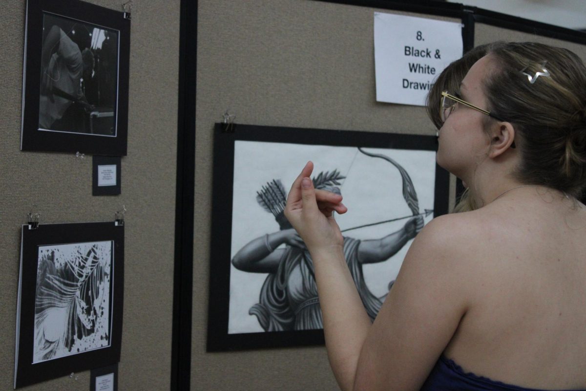 Margy Wittstruck, '28, observes displayed drawings at the WaMaC Art Competition.
