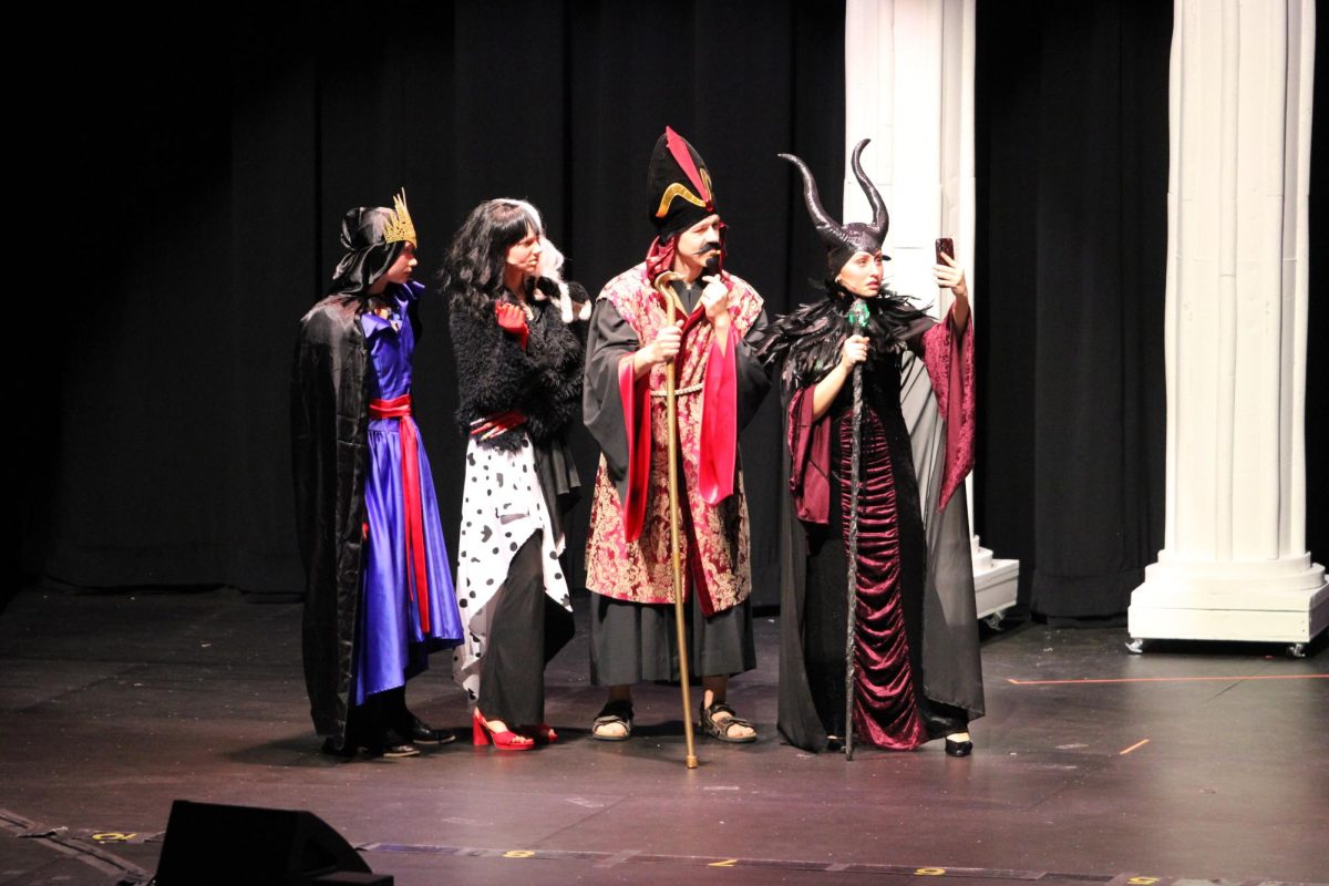 The villain parents (Brynlee Helverson, Ava Poggenklass, John Louzek, and Avery Booms) communicate with their children who are in Auradon.