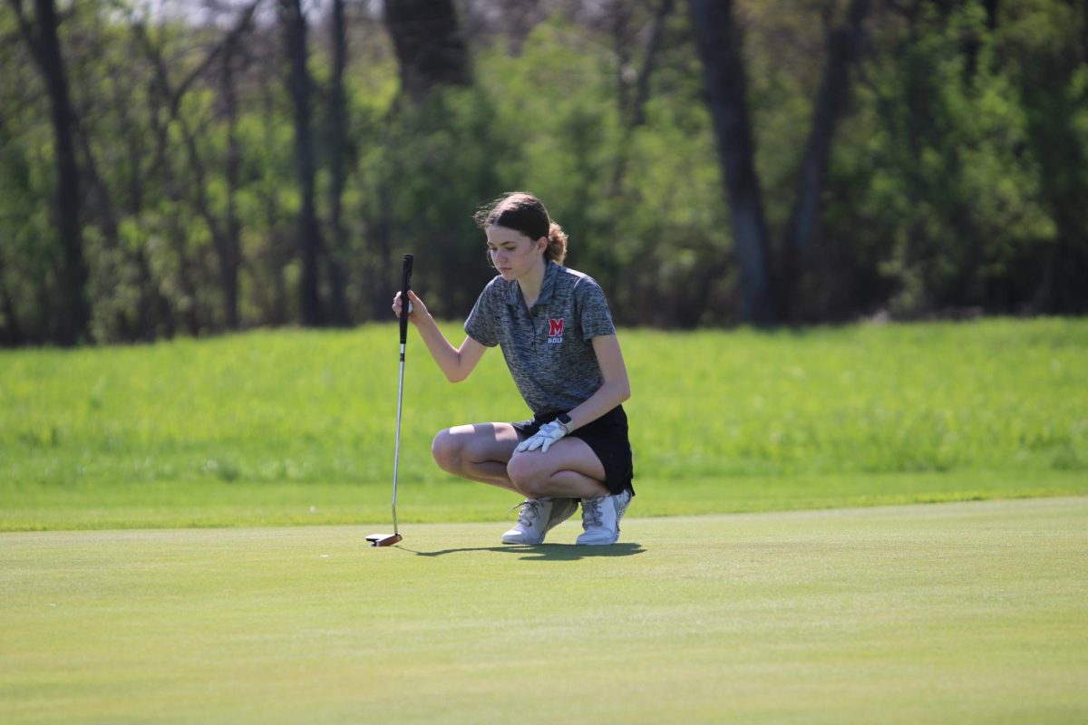 Taryn Oelmann, '28, sizes up her putt.
